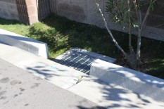 Drain at outlet for parking-lot runoff defeats purpose of swale.