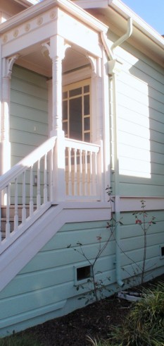 On new old-fashioned home, front roof leader leads to landscaping